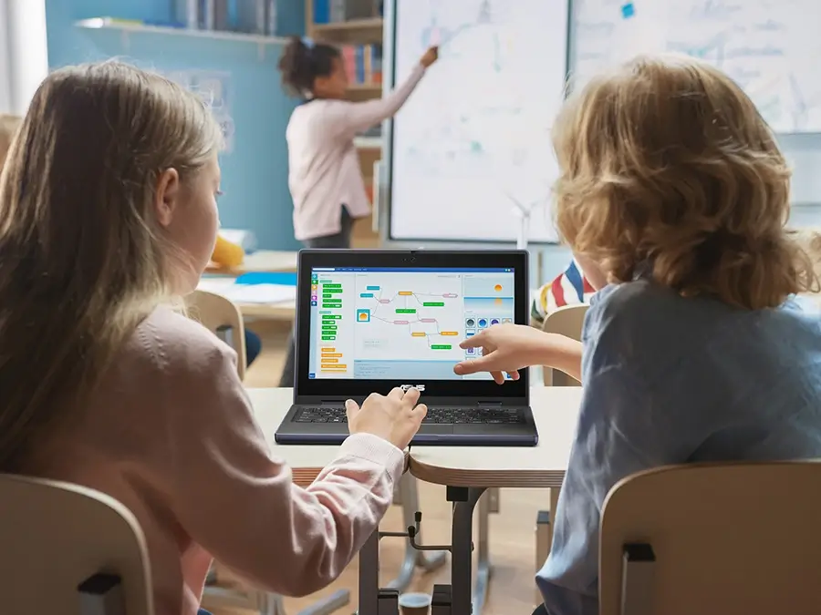 Two students working on a laptop