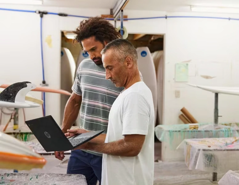 Two men using a laptop