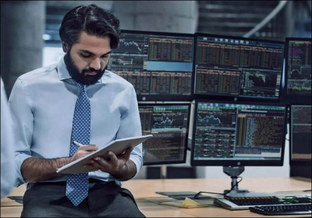 A man sitting in front of multiple monitors